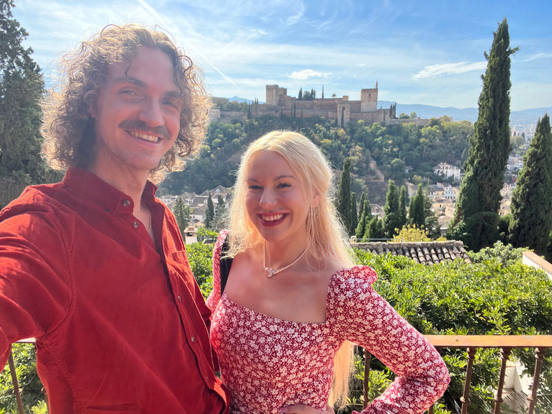 Two people taking a selfie with a castle in the background