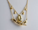 Gold necklace with a unique pendant on a gray background