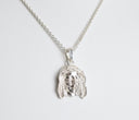 Silver pendant necklace on a light gray background