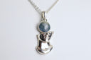 Silver pendant with a blue gemstone on a white background