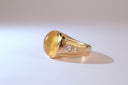 Gold ring with embedded diamonds on a light background