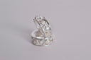 Pair of silver rings with intricate designs on a gray background