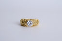 Gold ring with a diamond on a light gray background