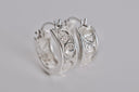 Silver hoop earrings with intricate designs on a gray background