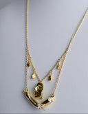 Gold necklace with a pendant on a light gray background