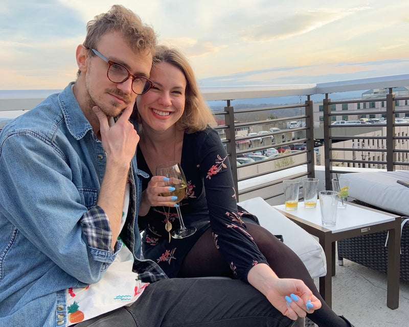 Two people sitting on a rooftop with cityscape in the background