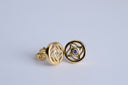 Gold earrings with gemstones on a light gray background