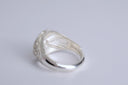 Silver ring with engraved design on a light gray background