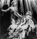 Black and white statue of a draped figure with flowing robes against a textured background