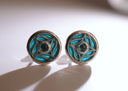 Pair of round earrings with blue and gold design on a white background
