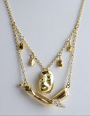 Gold necklace with a pendant on a light gray background