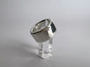 Silver ring on a clear stand against a gray background