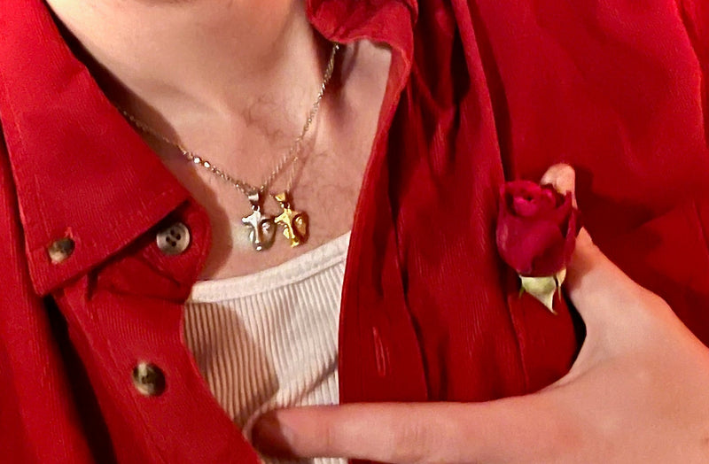 Person wearing a red jacket holding a small red rose, with a close-up on the hand and jacket.