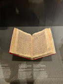 Open book with text on a dark reflective surface